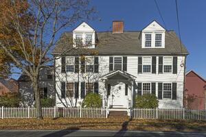 Color photo of exterior of the Timothy Root House viewed from the sidewalk to the south, with an autumnal tree in front of it