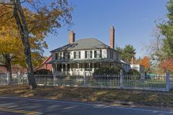 Colored photo of the Cowles House from across the street,with  autumnal trees