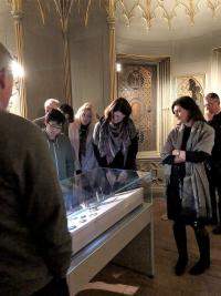 color photo of people looking at items on display in a case
