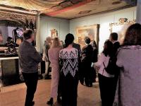 color photo of people in a room with paintings